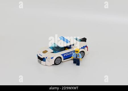 Ein Polizist Lego Minifigur und Polizeiauto mit einem weißen Hintergrund Stockfoto