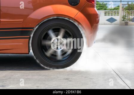 Der Rauch, der durch die Reibung von Reifen auf der Fahrbahn verursacht wird, wenn das Rad dreht. Stockfoto