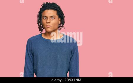 Junger afroamerikanischer Mann in lässigem Winterpullover, müde und müde, erschöpft von Müdigkeit und Kater, faule Augen am Morgen. Stockfoto