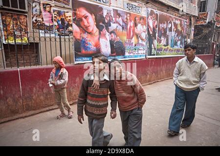 Delhi, Indien, Januar 2008. Wandernde Kinder vor Bollywood-Filmplakaten an der Wand. Stockfoto