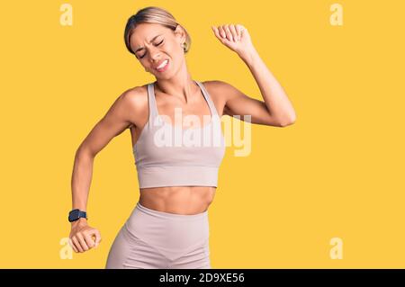 Schöne kaukasische Frau trägt Sportkleidung, die sich zurückstreckt, müde und entspannt, schläfrig und gähnend für den frühen Morgen Stockfoto