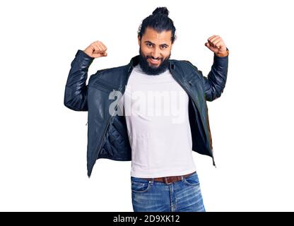 Junger arabischer Mann trägt lässige Lederjacke zeigt Arme Muskeln lächelnd stolz. Fitness-Konzept. Stockfoto