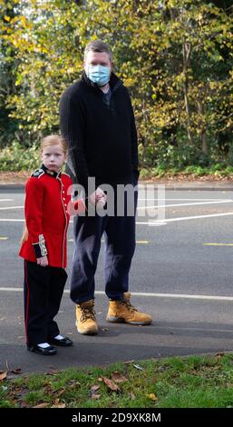 Biggin Hill,UK,8. November 2020,Trotz Lockdown besuchen Menschen einen Gedenkdienst in Biggin Hill Kent.EIN Kind in roter Soldatenuniform steht mit ihrem Vater. Kredit: Keith Larby/Alamy Live Nachrichten Stockfoto