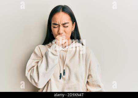 Junge asiatische Frau trägt lässige Sweatshirt Gefühl unwohl und Husten als Symptom für Kälte oder Bronchitis. Health Care Konzept. Stockfoto