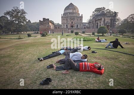 New Delhi, Indien, Februar 2009. Menschen, die sich vor dem Bara Gumbad-Komplex im Lodi-Garten, einem der beliebtesten Parks der Stadt, ausruhen. Stockfoto