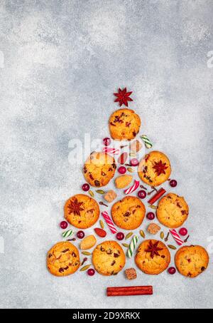Kulinarischer Hintergrund von Keksen mit Preiselbeeren, weißer Schokolade, Mandeln und Gewürzen in Form eines Weihnachtsbaumes. Zusammensetzung von Keksen, Cinnamo Stockfoto