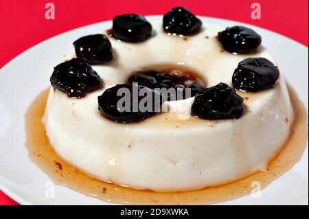 Köstliches traditionelles brasilianisches Dessert, bekannt als 'manjar de Coco Branco' mit Pflaumensoße. Traditionell zu Weihnachten und Neujahr in Brasilien konsumiert. Stockfoto