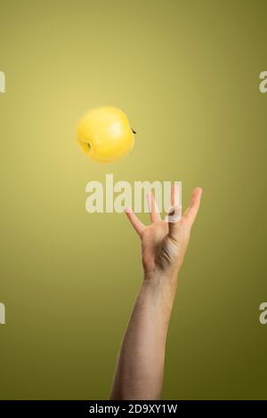 Hand fangen einen Apfel auf bunten Hintergrund, Studio-Foto Stockfoto