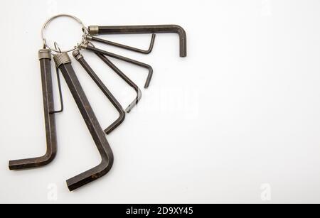Ein Satz von Sechskantschlüsseln, die auf einem Ring auf weißem Hintergrund hängen. Stockfoto