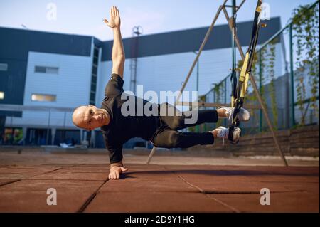 Sportlicher Mann tut Balance Übung im Freien Stockfoto