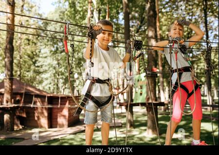 Kleine Mädchen und Jungen klettert im Seilpark Stockfoto