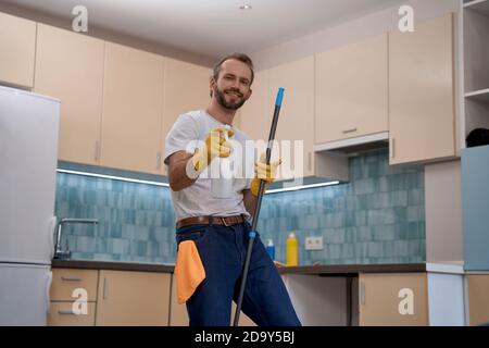Junger Kaukasischer Mann, der Waschmittel an die Kamera sprüht Stockfoto