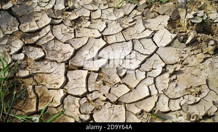 Globale Erwärmung Problem geknackt Erde und trockenes Wasser ist weicher Fokus, Vollbildaufnahme von geknacktem Land, Bodenstruktur, verblasst, schwache Reds Stockfoto