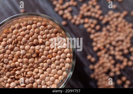 Draufsicht auf die Linsen sind in einem Glas Wasser eingeweicht. Vorbereitung für die keimenden Linsen Stockfoto