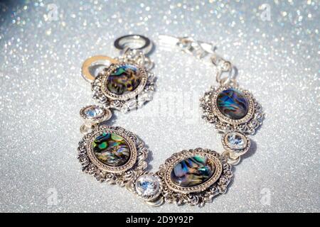 Fashion Retro Silber Armband mit dunklen Regenbogen Abalone Schale auf Glitzer Hintergrund verziert. Stockfoto