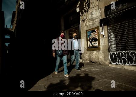 Barcelona, Spanien. November 2020. Ein Paar geht an einem Graffiti des italienischen Stadtkünstlers 'TVBoy', Salvatore Benintende, vorbei, das "If I Can Change and You Can Change, Everybody Can Change" betitelt und den gewählten US-Präsidenten Joe Biden nach dem Wahlkampf bei den US-Wahlen 2020 darstellt.Quelle: Matthias Oesterle/Alamy Live News Stockfoto