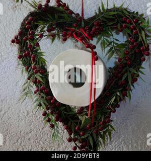 Moorrolle in einem Blumenkranz Dekoration - in Zeiten Von Corona Covid19 scheint Toilettenpapier eine wichtige Rolle zu spielen Problem Stockfoto