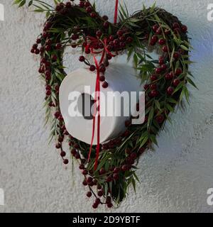 Moorrolle in einem Blumenkranz Dekoration - in Zeiten Von Corona Covid19 scheint Toilettenpapier eine wichtige Rolle zu spielen Problem Stockfoto