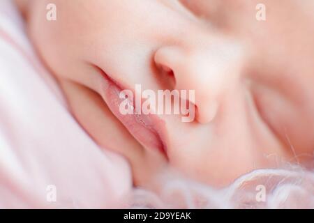 Kaukasischen Neugeborenen Baby Gesicht Nahaufnahme Makro Detail Aufnahme. Kind Porträt, Gesundheit Haut, Zärtlichkeit, Mutterschaft und Babyschaft Konzept - Bild. Weich selektiv Stockfoto