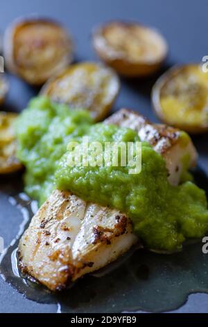 Kabeljaufisch mit grüner Spargelsauce und gebratenen Kartoffeln Stockfoto