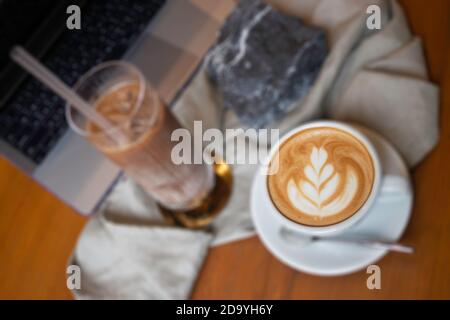 Heißer Kaffee und Eiskaffee auf Holztisch, Foto Stockfoto