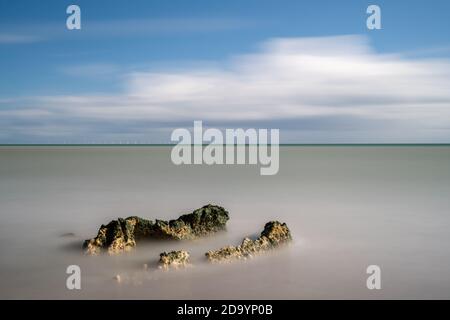 Felsen in einem flachen ruhigen Meer Stockfoto