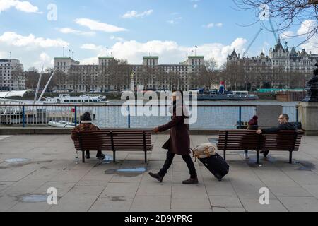 Mann mit einem Wheelie Koffer auf der South Bank London Stockfoto