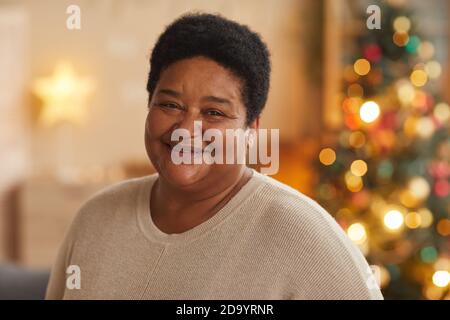 Nahaufnahme Porträt von lachenden afroamerikanischen Oma Blick auf die Kamera, während Weihnachten zu Hause genießen, kopieren Raum Stockfoto