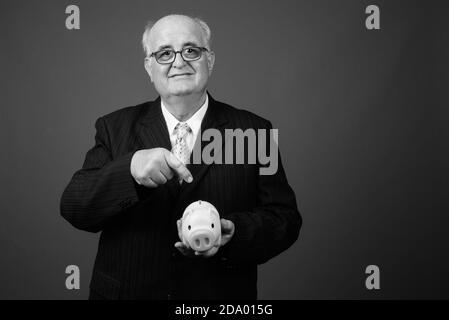 Übergewichtiger Geschäftsmann mit Brillen vor braunem Hintergrund Stockfoto