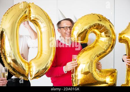 Geschäftsleute feiern Urlaub im modernen Büro, trinken Champagner und haben Spaß im Coworking. Frohe Weihnachten und ein glückliches neues Jahr 2021. Ball Stockfoto