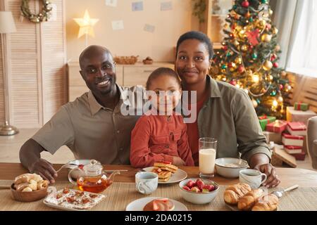Porträt einer glücklichen afroamerikanischen Familie, die Tee und Süßigkeiten genießt Feiern Sie Weihnachten zu Hause in gemütlichen Hause Interieur Stockfoto