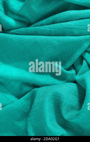 Draufsicht auf zerknittertes grünes Gewebe. Vertikaler leerer Textilhintergrund Stockfoto