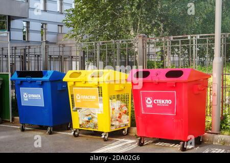 Drei Abfallbehälter rot, blau und gelb an einem Sommertag. Übersetzung: Papier, Plastik, Glas Stockfoto