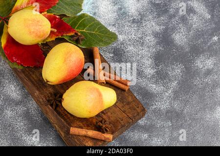 Birnen auf hellem Hintergrund. Herbstkonzept. In der Nähe sind getrocknete Birnenstückchen und Nüsse. Speicherplatz kopieren. Stockfoto