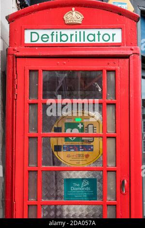 Der Defibrillator befindet sich in einer nicht mehr verwendeten roten Telefonbox bei Saffron Walden England Stockfoto