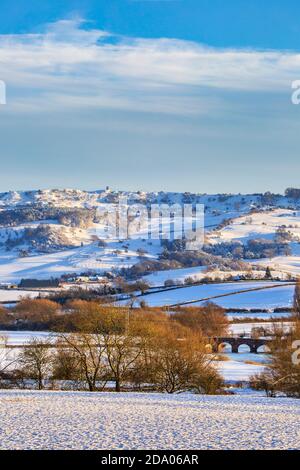 Schneebedeckte Bredon Hügel und Eckington Brücke über den Avon in den Cotswolds AONB, Worcestershire, England Stockfoto