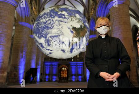 Canon Celia Thomson von der Gloucester Cathedral. Er hat die ganze Welt in seinen Händen, genauer gesagt die ganze Erde in der Gloucester Cathedral. Stockfoto