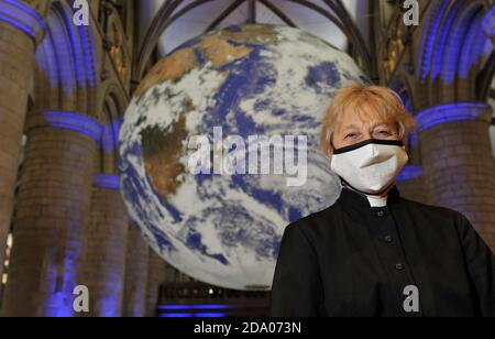 Canon Celia Thomson von der Gloucester Cathedral. Er hat die ganze Welt in seinen Händen, genauer gesagt die ganze Erde in der Gloucester Cathedral. Stockfoto