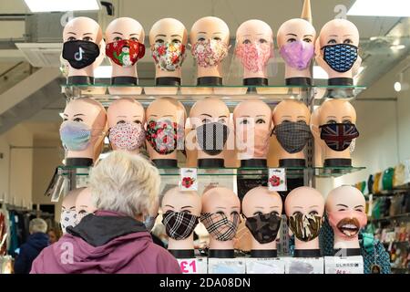Frau, die Gesichtsmasken im Laden in Glasgow, Schottland, Großbritannien, ansieht Stockfoto
