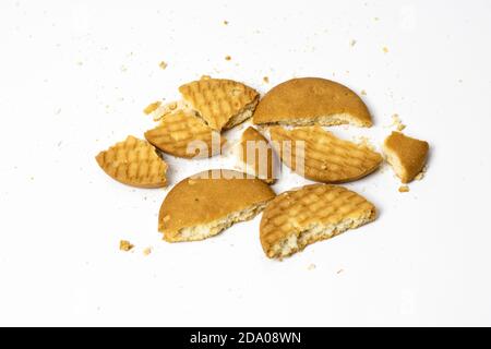 Gebrochene Weizenkekse auf weißem Hintergrund verstreut Stockfoto
