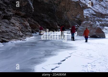 Abenteuerliche Höhenwanderungen auf dem gefrorenen Zanskar Fluss [ Chadar Trek ] im Winter in Ladakh in Indien tragen Rucksack und Spazierstock Stockfoto