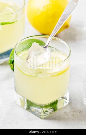 Gelee mit Zitrone und Limette im Glas, grauer Hintergrund, selektiver Fokus Stockfoto