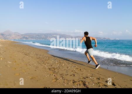 Läufer sprinten zum Erfolg Laufen auf nassem Sand am Strand. Männlicher Athlet Sprintertraining für Wettkampfschnellsprintung Lauf auf nassem Sand bei t Stockfoto