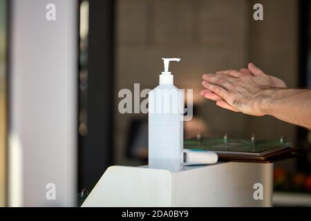 Antibakterielle Händedesinfektionsflasche am Gebäudeeingang für Menschen, die sich die Hände waschen, um die Ausbreitung des Coronavirus-Ausbruchs zu stoppen covid-19 für die öffentliche Gesundheit Sicherheit, Mann tragen es auf der Hand. Nahaufnahme Stockfoto