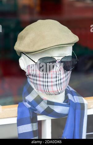 Schaufensterpuppe Kopf trägt Gesichtsmaske und Sonnenbrille in einem Geschäft Schaufenster, während der zweiten nationalen Sperre, Oxford Street, London, 7 Novemb Stockfoto