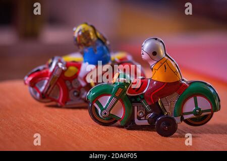 Antike Zinn Spielzeug Motorräder auf einem orangen Tisch. Stockfoto