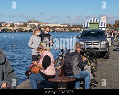 PRAG, TSCHECHISCHE REPUBLIK - 24. OKTOBER 2020: Menschen in Gesichtsmasken entspannen auf dem Bauernmarkt Naplavka während der zweiten Welle des Coronavirus outb Stockfoto