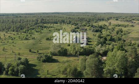 Das russische Dorf aus der Höhe. Traurige russische Sommerdorf Landschaft. Die Häuser in einem verlassenen Dorf sind mit Gras bewachsen. Stockfoto