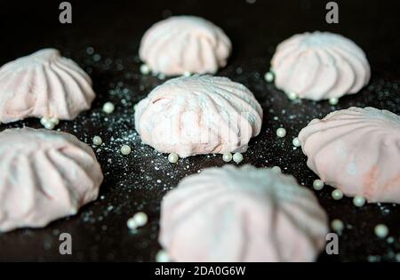 Rosa Marshmallow auf dunklem Hintergrund. Weiße und rosa süße hausgemachte Marshmallows oder zephyr. Der Blick von oben Stockfoto