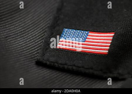 Gestickte amerikanische Flagge auf dunklem Stoff.USA Flagge auf schwarzem Hintergrund. Amerikanische Stickerei. Stockfoto